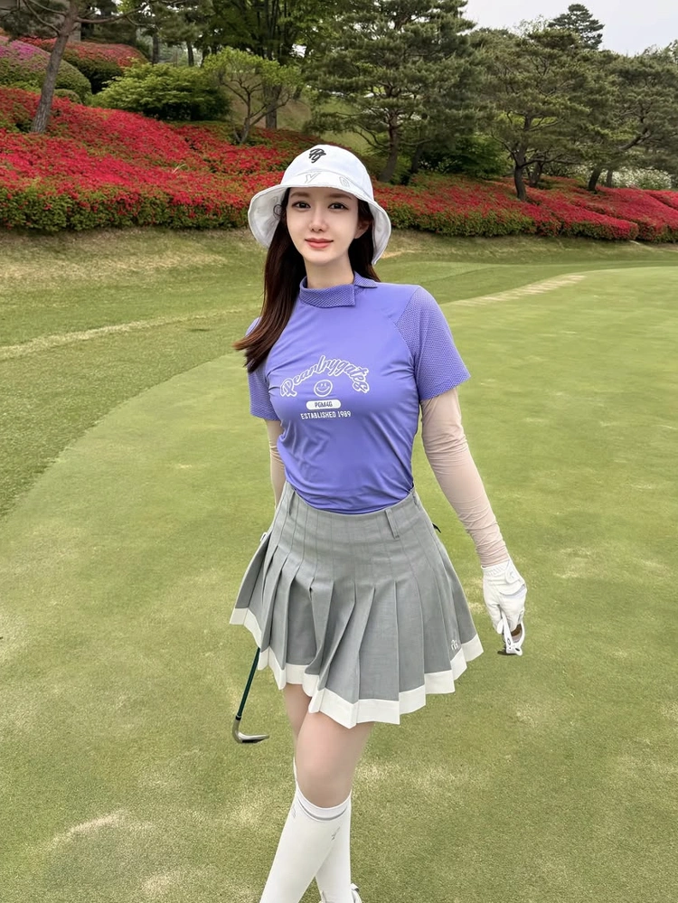 Áo golf nữ Pearly Gates tím cổ tàu phối vải lưới thoáng mát, người mẫu kết hợp chân váy xếp ly xám trắng trên sân golf